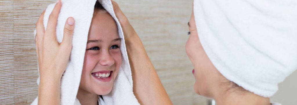 mother towel drying daughters hair