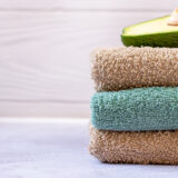 A Stack Of Three Bath Towels Of Brown And Turquoise Colors On A